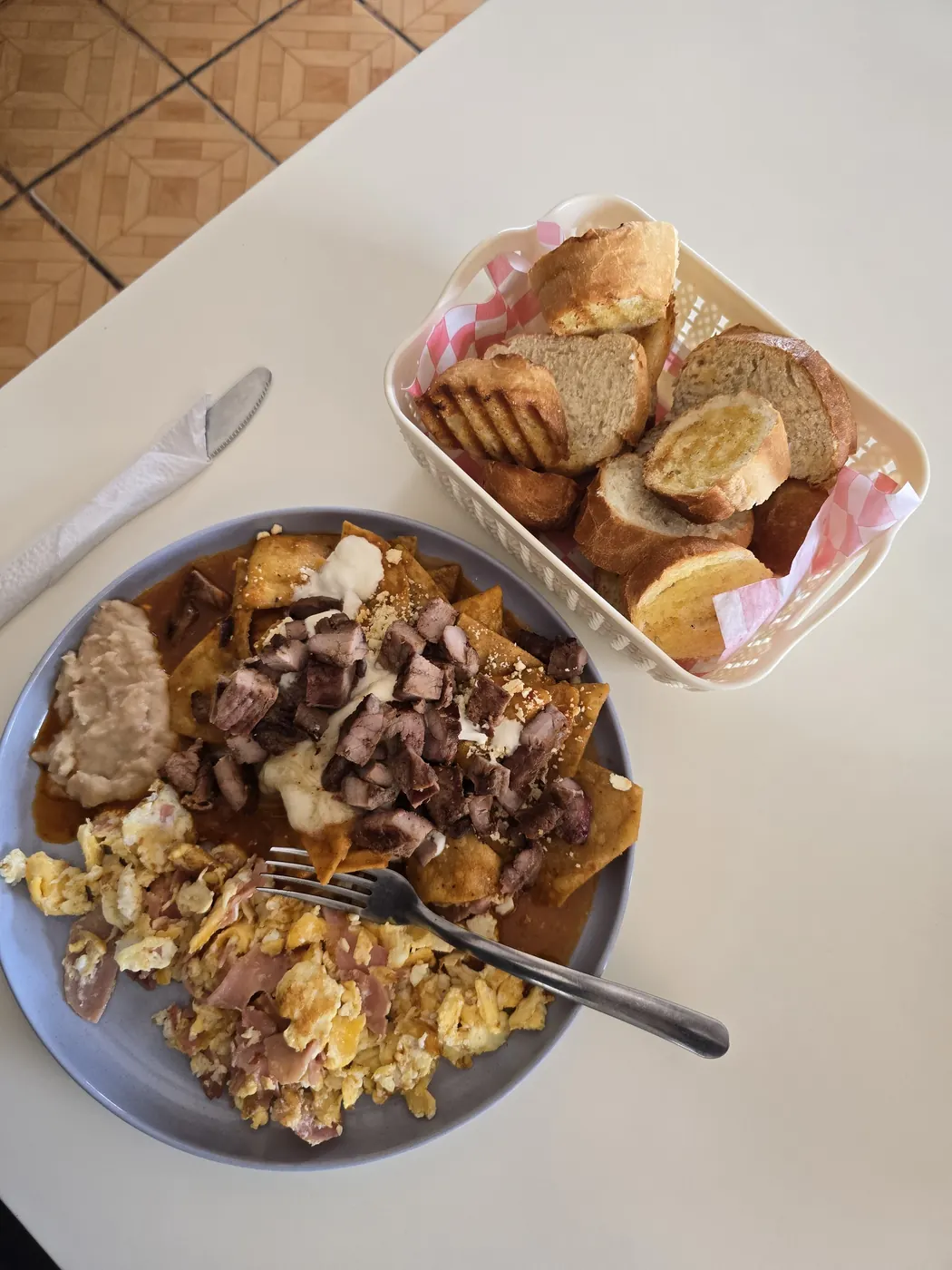 Desayuno de chilaquiles servido con pan