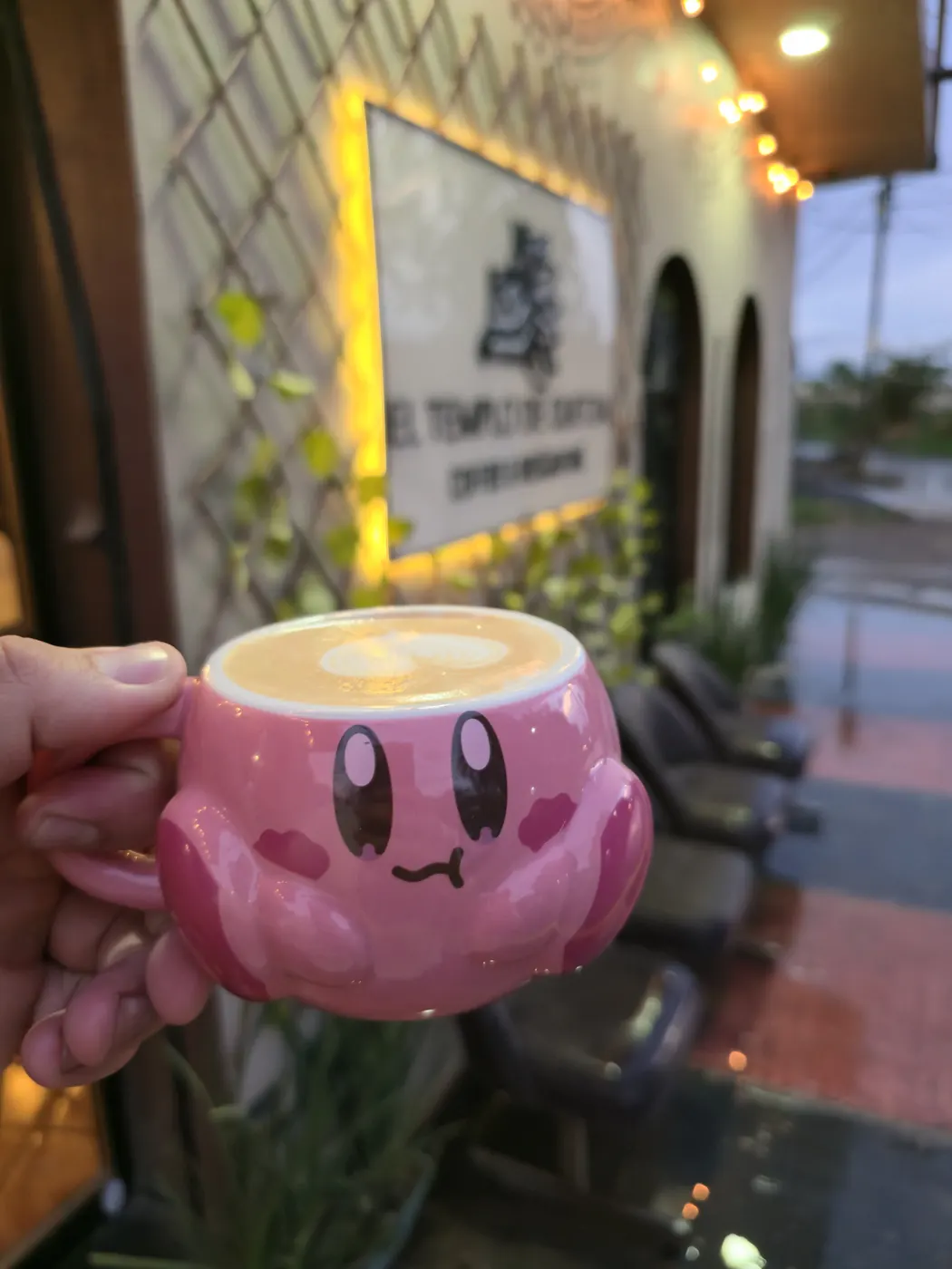Taza rosa de café frente al restaurante